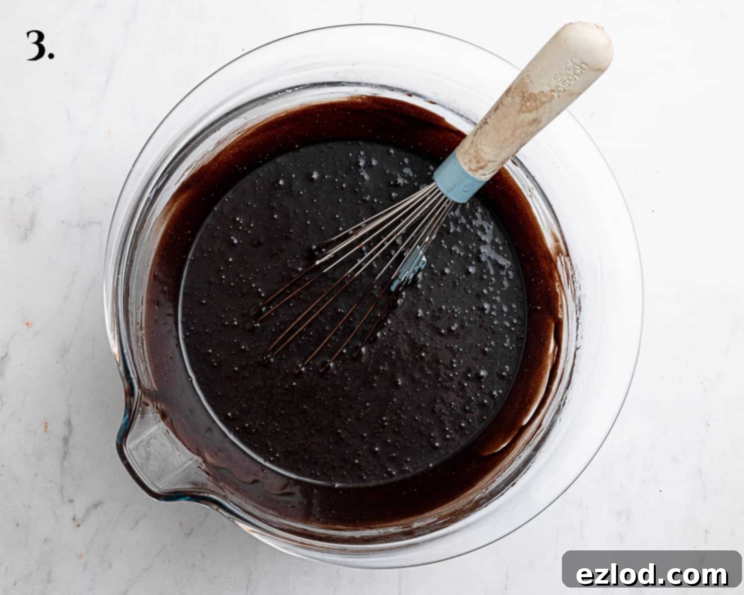Decadent Vegan Chocolate Bundt Cake 7 Step 3 of the vegan chocolate bundt cake recipe, illustrating all the wet ingredients – oil, yogurt, sugar, and vanilla extract – perfectly combined in a bowl.