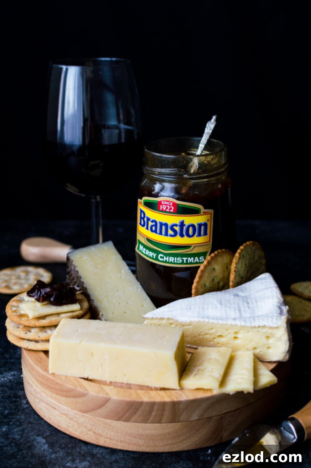 Branston pickle, cheese and wine spread on a wooden board
