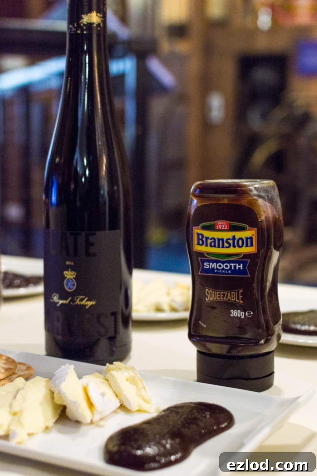 Brie cheese, a glass of dessert wine, and a jar of Branston Smooth Squeezy Pickle