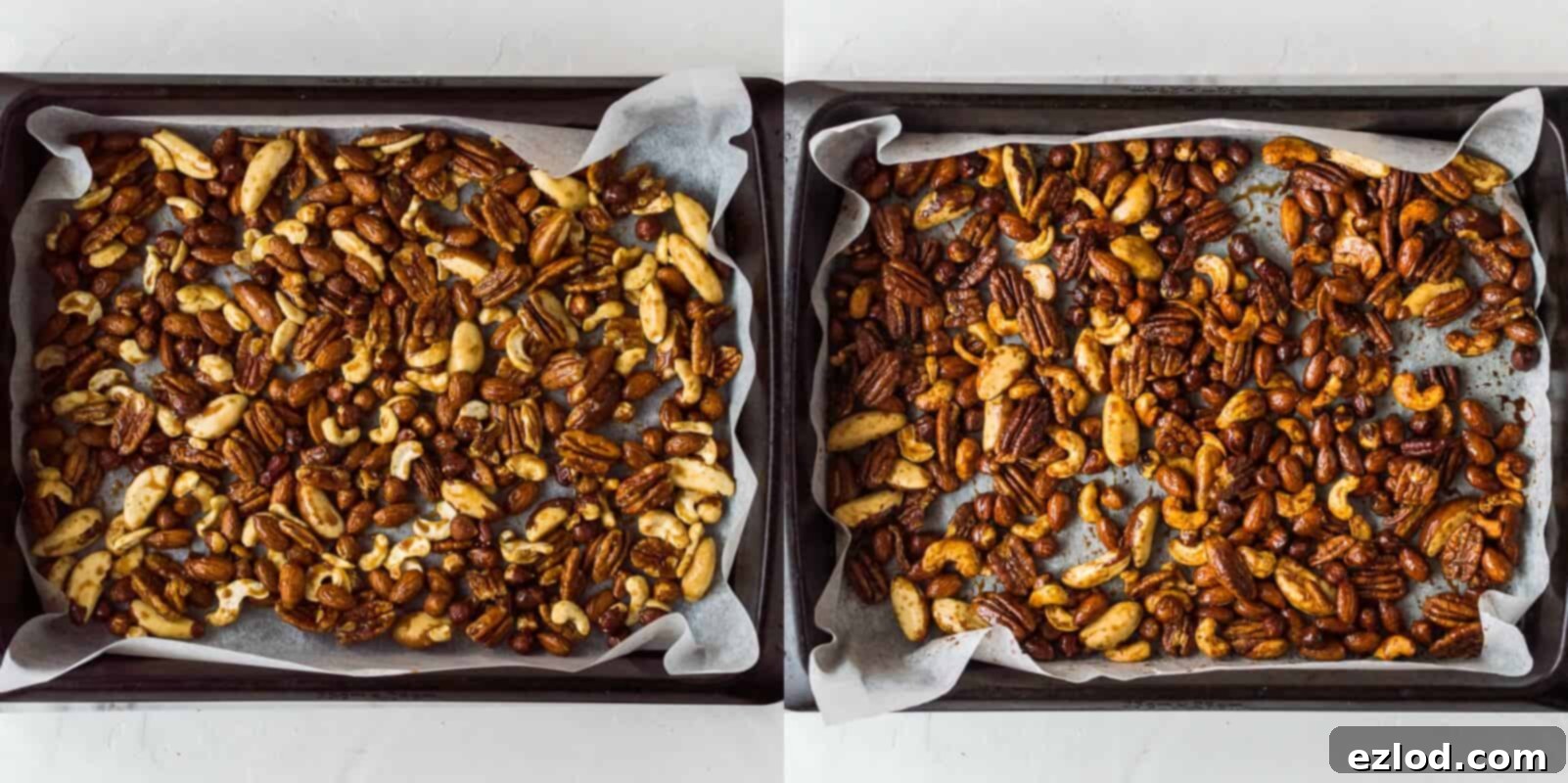Roasted nuts spread evenly on a parchment-lined baking sheet, half-way through the roasting process, showing a developing golden-brown hue.