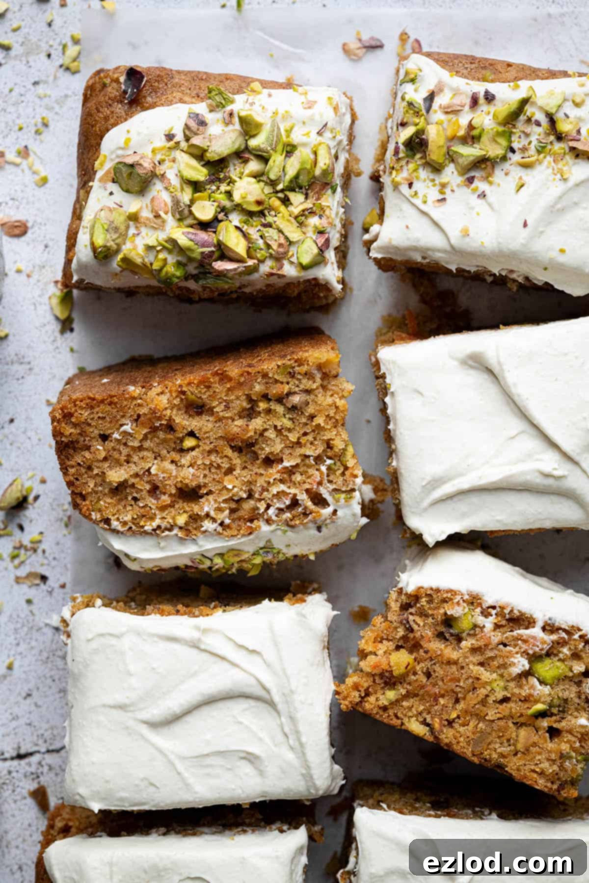 Squares of vegan carrot, pineapple and pistachio cake, artfully arranged.