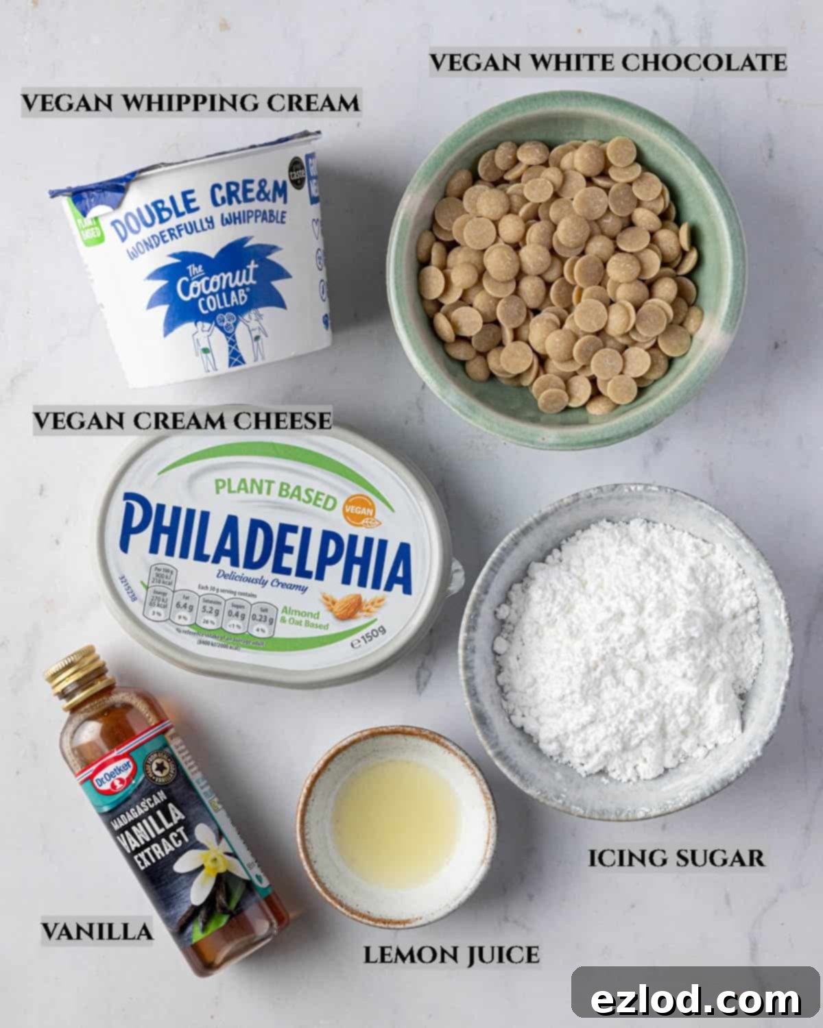 A labelled photo of the ingredients needed to make white chocolate cream cheese whipped cream, including vegan whipping cream, vegan cream cheese, and white chocolate.