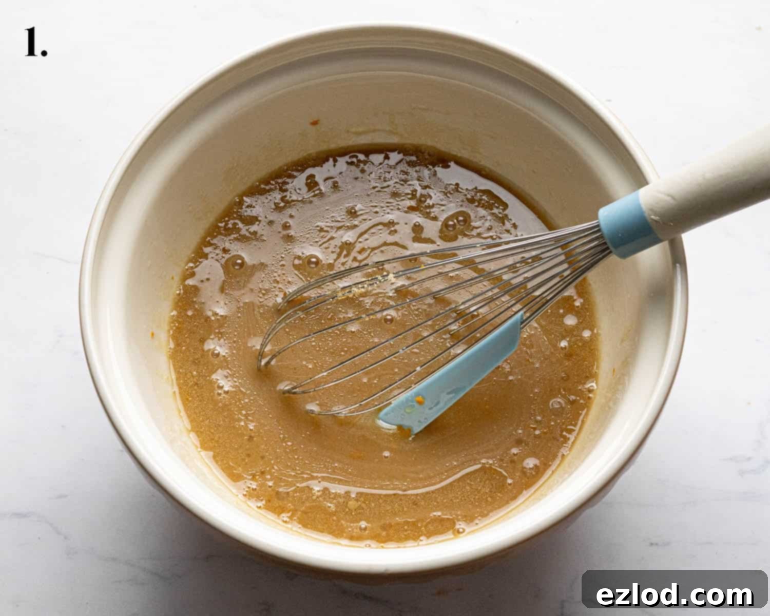 Step 1: Wet ingredients being whisked in a bowl for the vegan carrot cake batter.