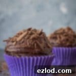 Decadent Vegan Chocolate Cupcakes for Two 3 Two vegan chocolate cupcakes in purple cake cases, perfectly baked and ready for frosting.