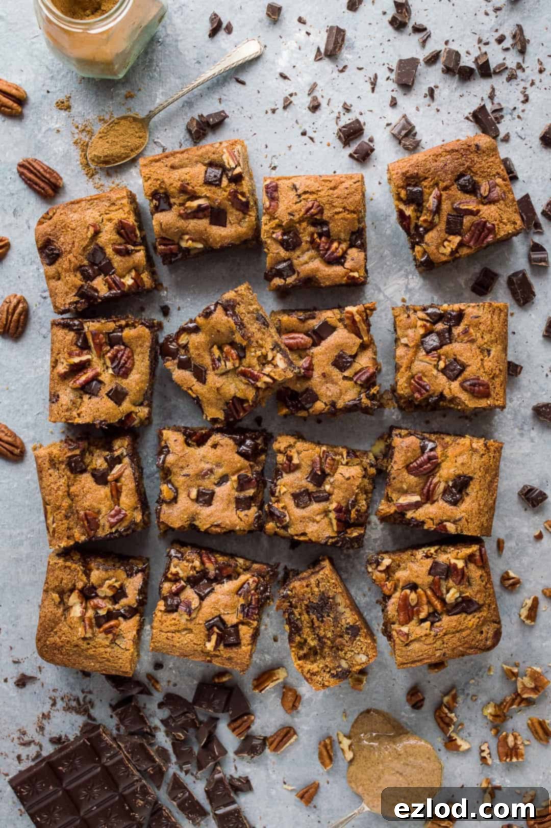 Deliciously moist vegan peanut butter chocolate chip pecan bars stacked on a rustic wooden board, ready to be enjoyed as a snack or dessert.
