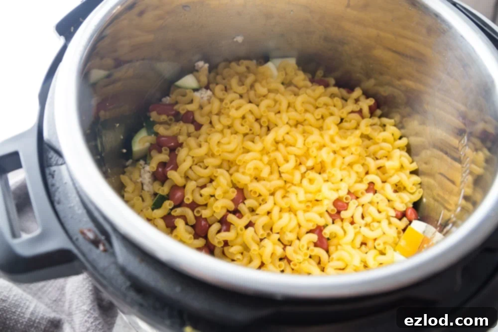 The process of making healthy chili mac showing chopped vegetables and spices. This Healthy Instant Pot Chili Mac is the perfect pairing of two of my favorite meals:  chili and mac and cheese.  Perfectly portioned for the 21 Day Fix, and gluten-free, too!  This is a healthy meal for the whole family! Healthy Instant Pot | Instant Pot Chili Mac | 21 Day Fix Chili Mac | 21 Day Fix Recipes | 21 Day Fix Instant Pot Recipes | Portion Fix #healthyinstantpot #confessionsofafitfoodie #21dayfixrecipes #21df