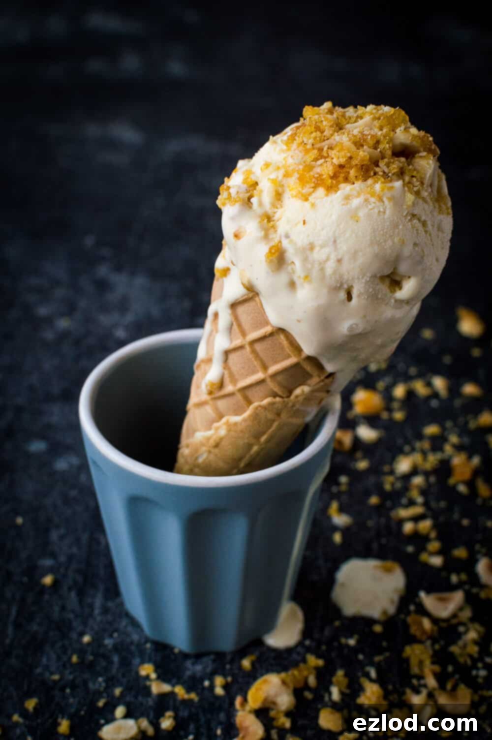 Hazelnut praline vanilla ice cream in a cone topped with crushed hazelnut praline.