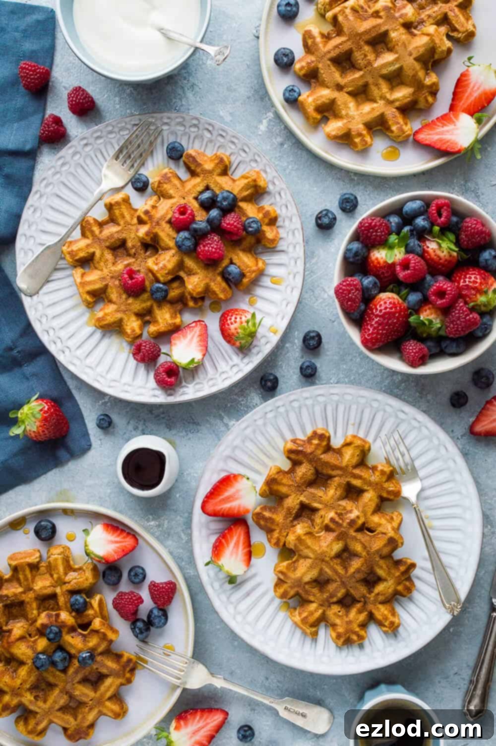 A stack of golden-orange sweet potato waffles, looking light and crispy, ready to be served for a healthy breakfast.