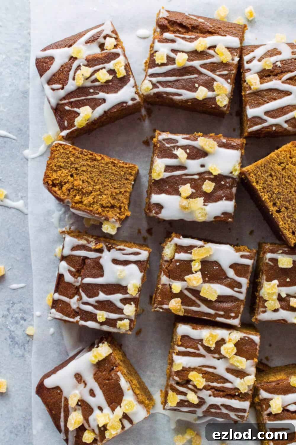Sliced vegan ginger sheet cake topped with a vibrant lemon glaze and crystallised ginger pieces, ready to be served.