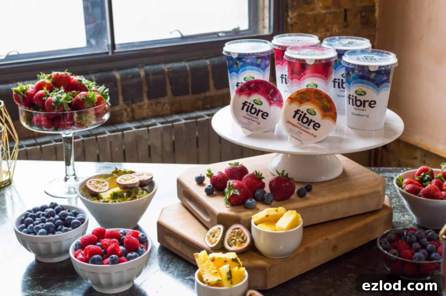 Arla Fibre yogurts alongside fresh fruit, illustrating their delicious and natural integration into a healthy diet.