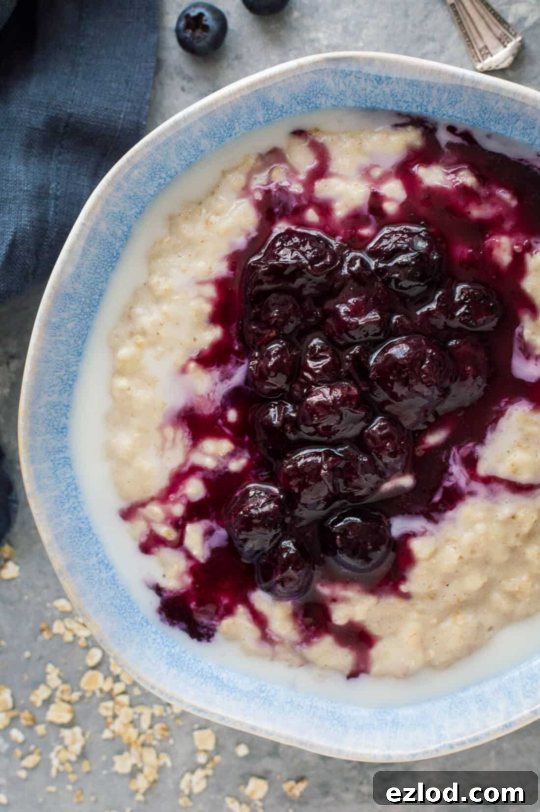 Golden Banana Oats with Blueberry Swirl 3 Close up shot of creamy banana porridge topped with vibrant blueberry compote, ready to be enjoyed as a healthy breakfast.