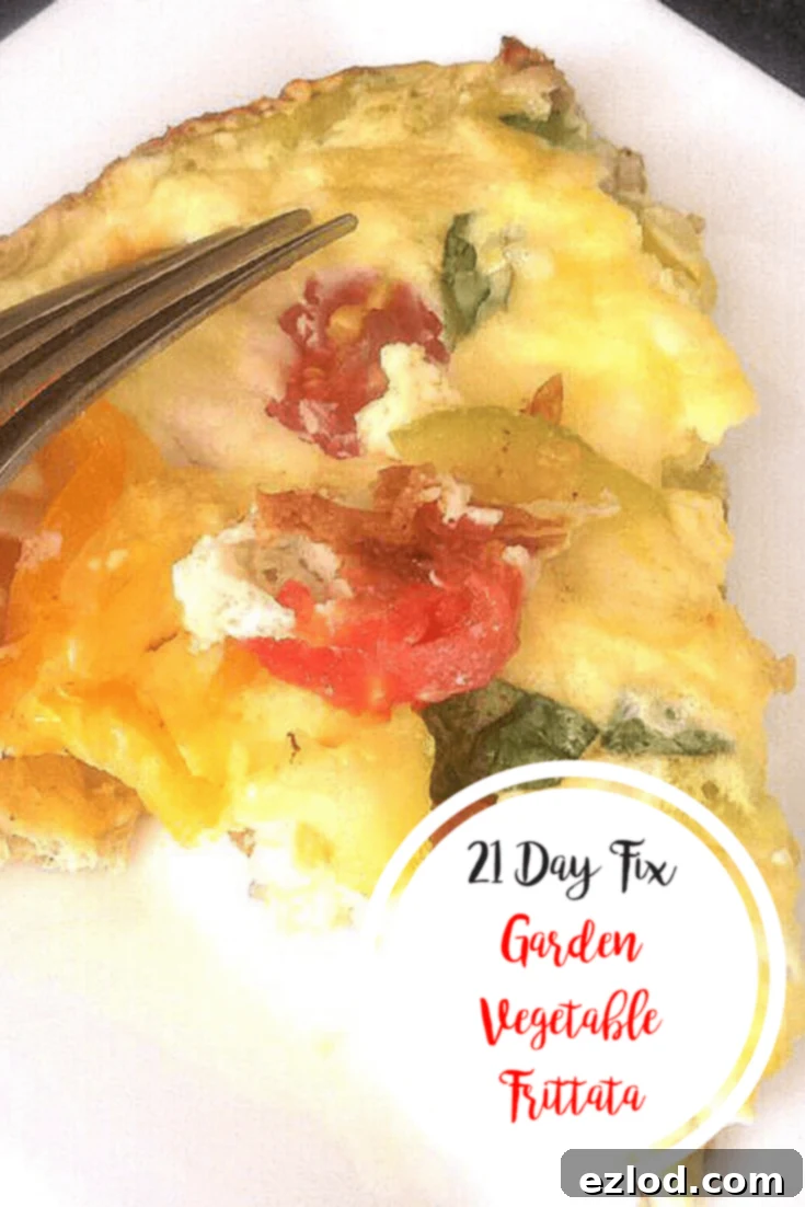 A triangular slice of fritatta on a white plate with tomatoes, zucchini, and basil peeking through the egg dish- with the text overlay 21 Day Fix Garden Vegetable Frittata