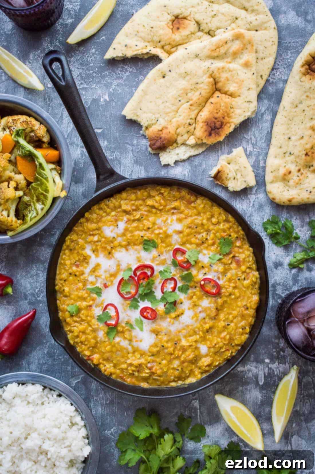 A vibrant plate of Red Lentil Dhal with perfectly roasted cauliflower & butternut squash, topped with fresh coriander. A healthy, delicious, and easy vegan meal.