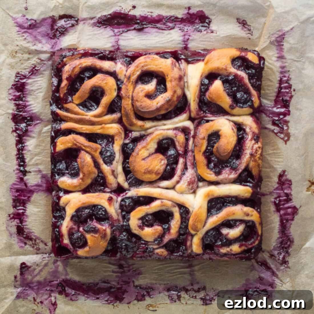 Nine vegan lemon blueberry rolls in a square on a sheet of baking parchment.