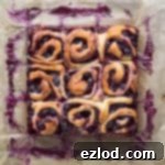 Nine vegan lemon blueberry rolls in a square on a sheet of baking parchment.