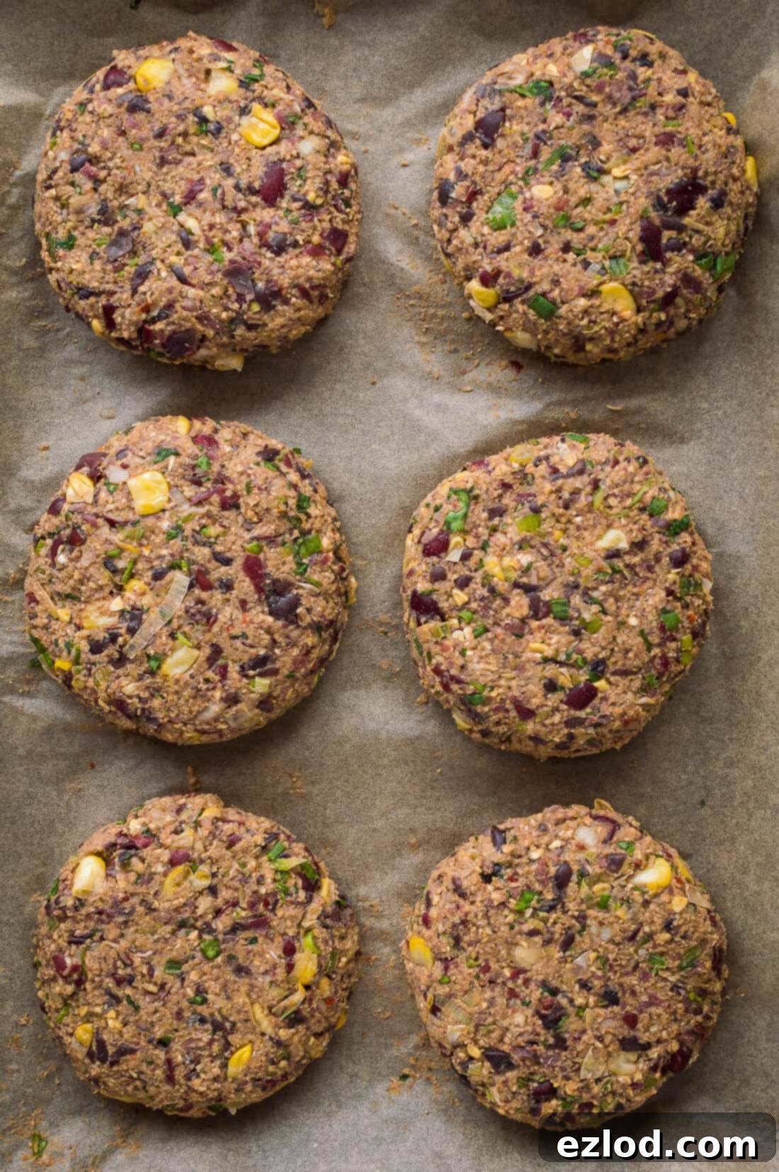 Uncooked vegan Mexican black and kidney bean burger patties, perfectly shaped and ready for cooking.