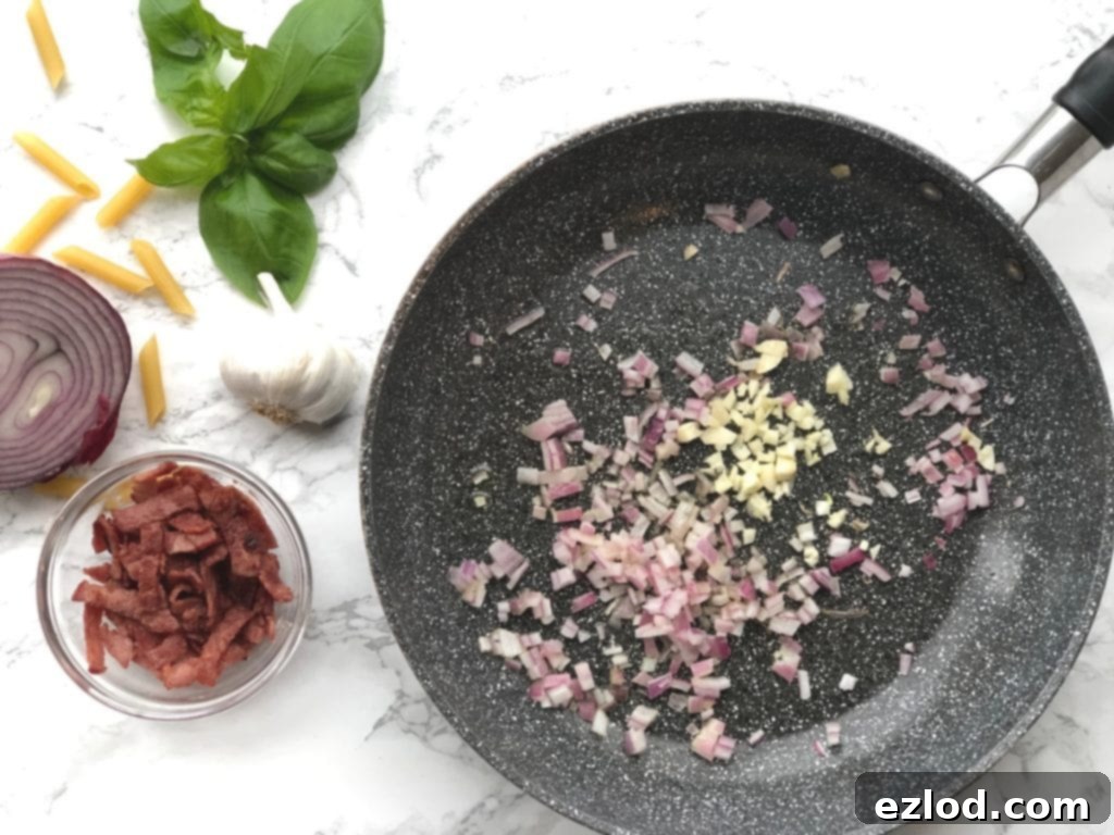 Skillet with red onion, garlic, bacon and basil on the side