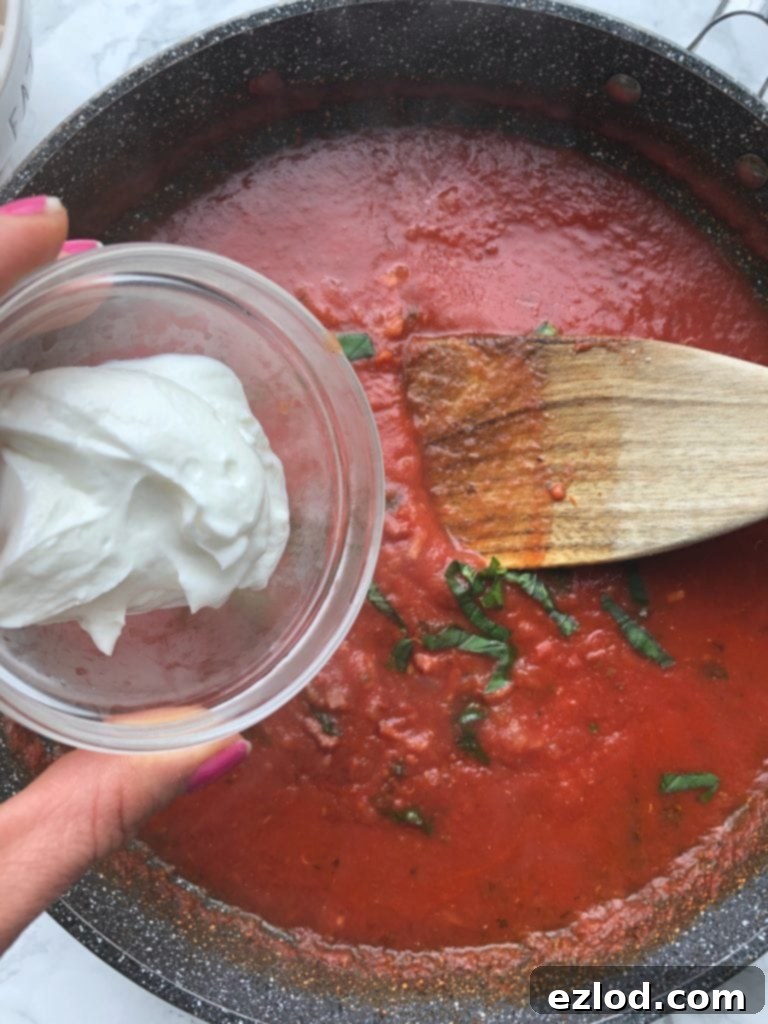 A skillet and a small bowl of plain Greek yogurt for a Healthy Vodka Sauce