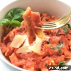 Wholesome Chicken Penne Vodka Pasta 10 Healthy Penne Vodka with Chicken in a white bowl with a fork, showing creamy pink sauce and chicken pieces.