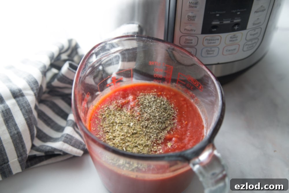 A measuring cup of sauce and spices next to an Instant Pot