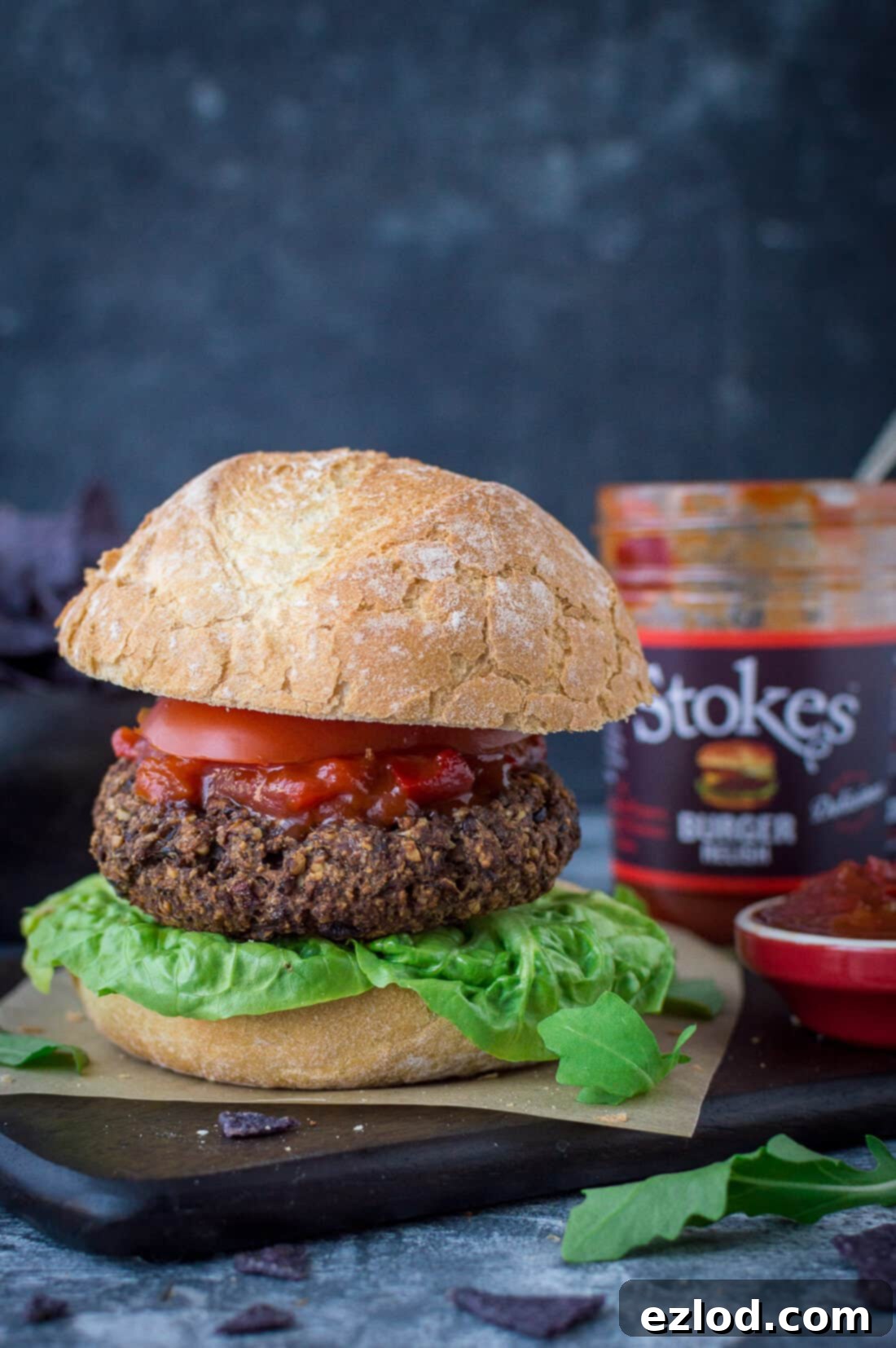 A delicious vegan mushroom lentil burger served in a bun with fresh toppings and a generous dollop of Stokes burger relish, highlighting the perfect pairing.