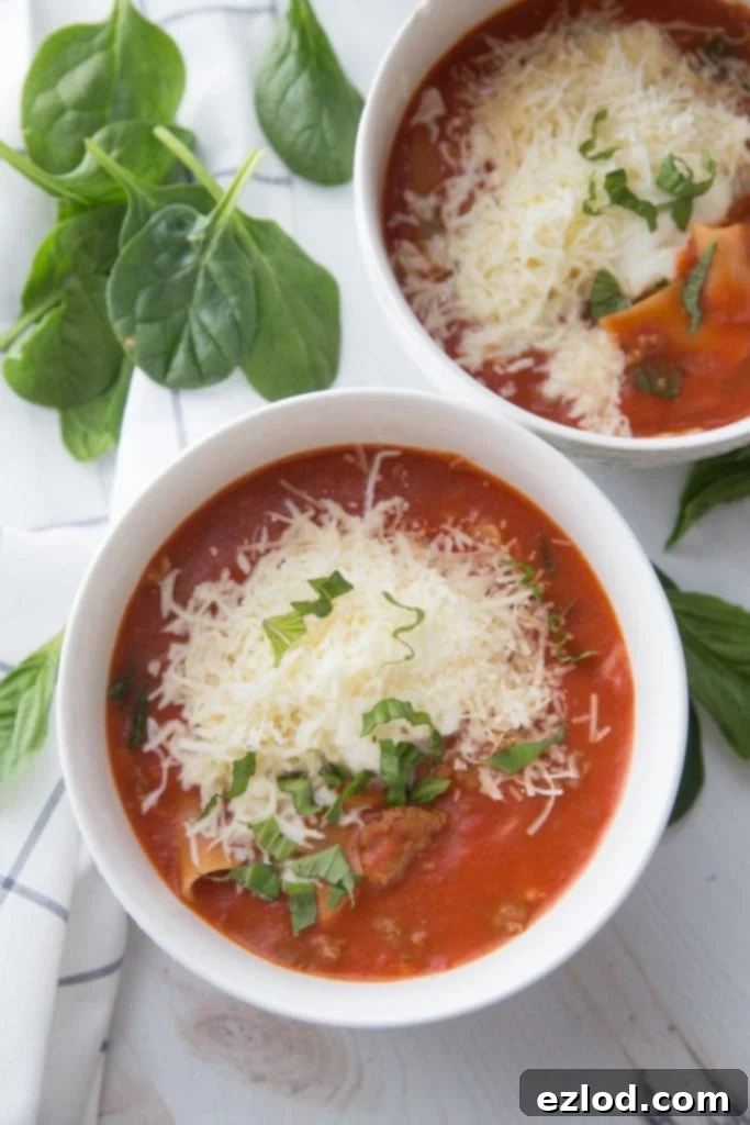 Two bowls of healthy gluten free instant pot soup sitting on a white backdrop next to basil leaves and spinach
