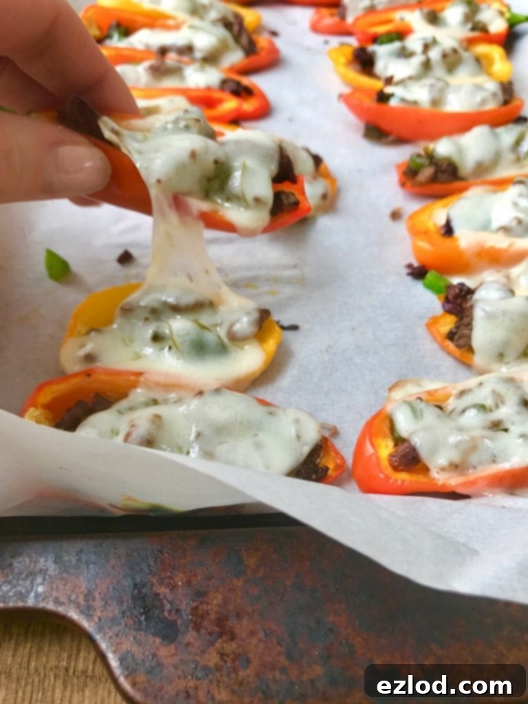 Mini Philly Cheesesteak Stuffed Pepper Nachos made in the Instant Pot, lined on a sheet pan and topped with gooey provolone cheese