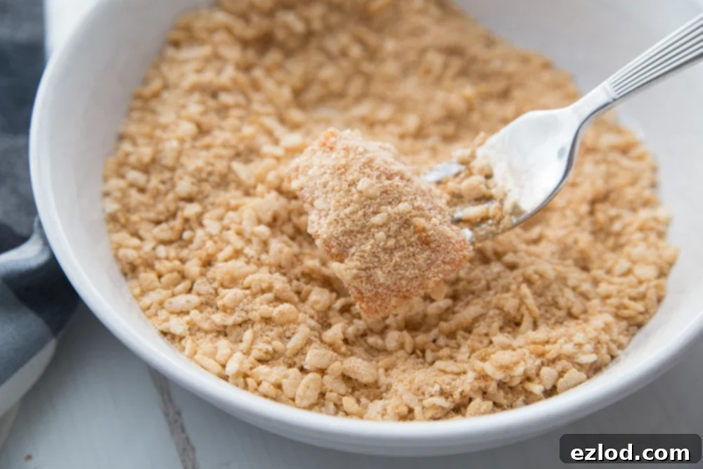 A bowl of seasoned brown rice cereal being used a breading for buffalo chicken nuggets