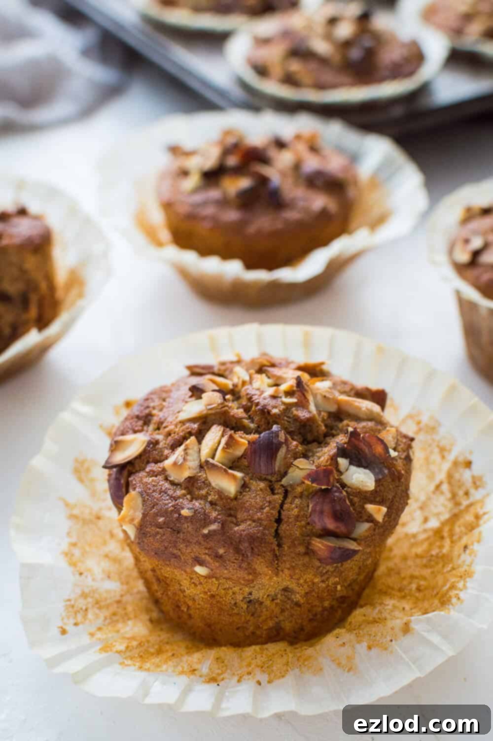 Close up of a vegan banana nut muffin in a white muffin liner.