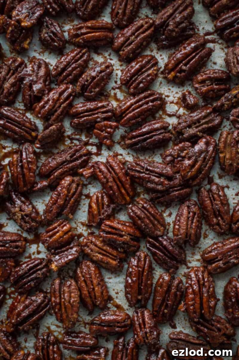 Sweet and crunchy maple pecans cooling on a baking tray, ready to be used as a topping for the vegan pumpkin cake.