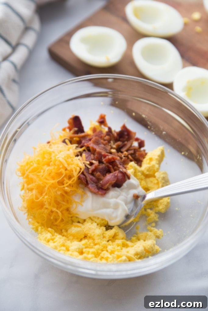 Instant Pot Deviled Eggs garnished with bacon, chives, and paprika on a decorative plate