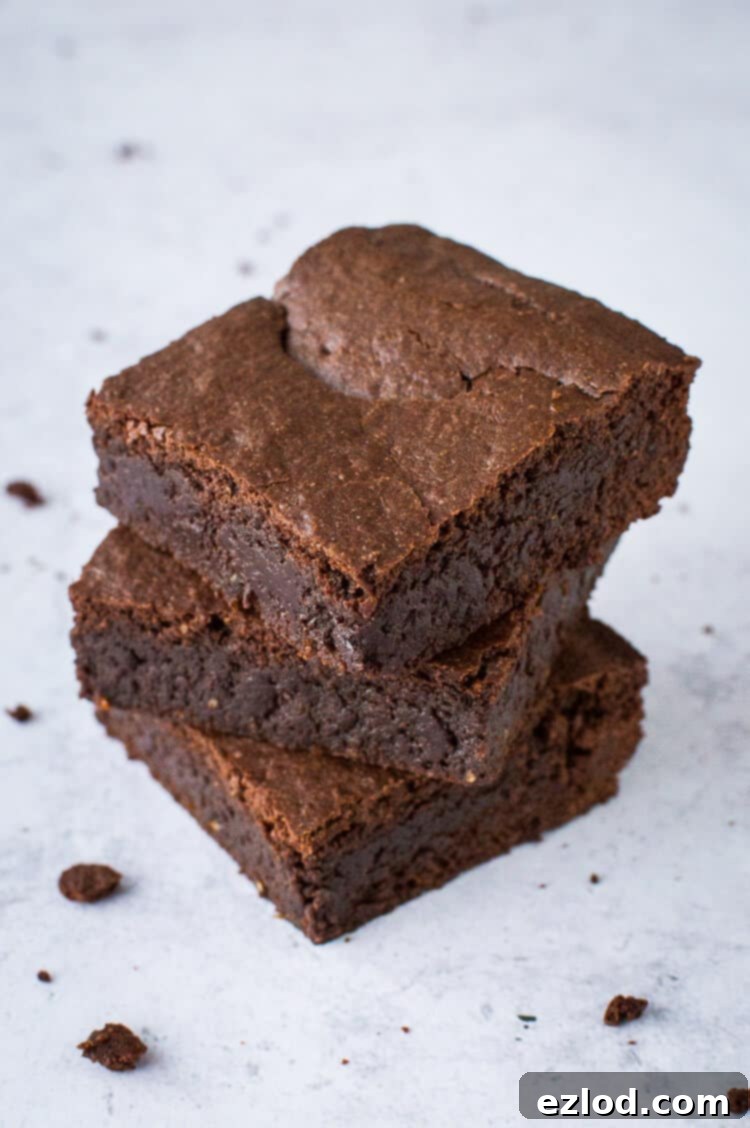 a stack of three fudgy vegan mulled wine brownies on a grey background.