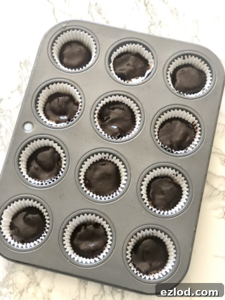 A mini muffin tin filled with healthy homemade peanut butter cups 