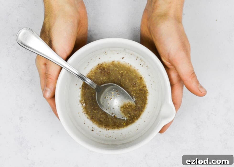 Step 2: Mixing ground flaxseed with water in a small bowl to create a vegan flax egg substitute, which is then set aside to thicken.