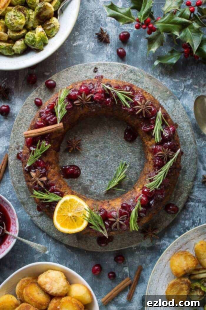 Festive vegan nut roast wreath, beautifully garnished with cranberries and rosemary, ready for a special Christmas dinner. #vegan #christmas #nutroast
