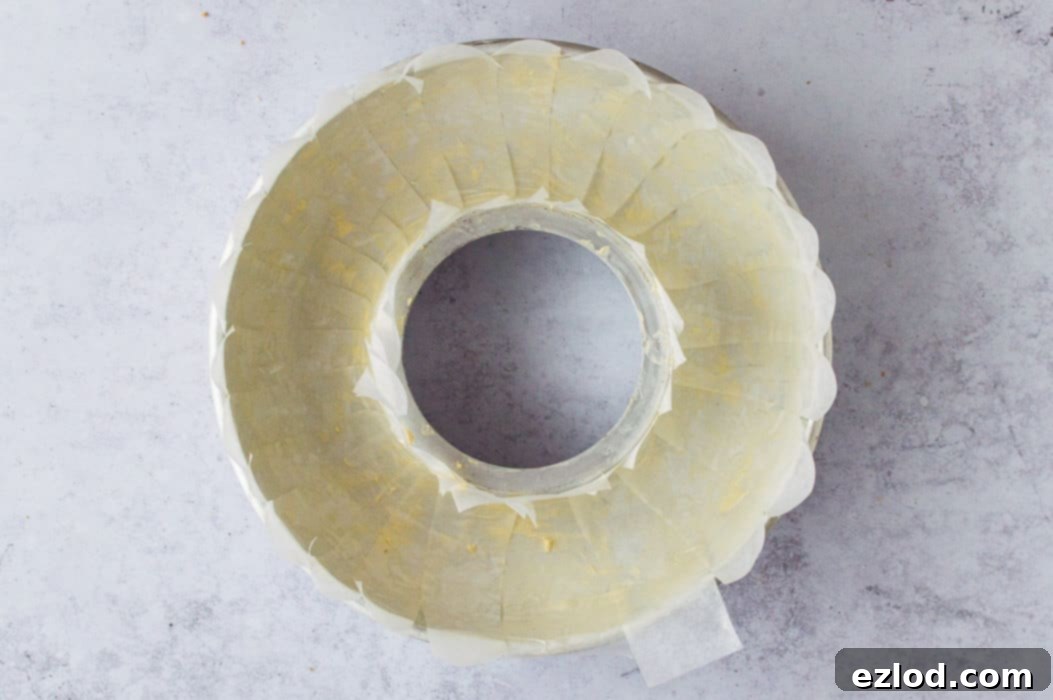 Step-by-step image illustrating the proper method of lining a ring tin with baking parchment for the festive vegan nut roast, ensuring easy removal.