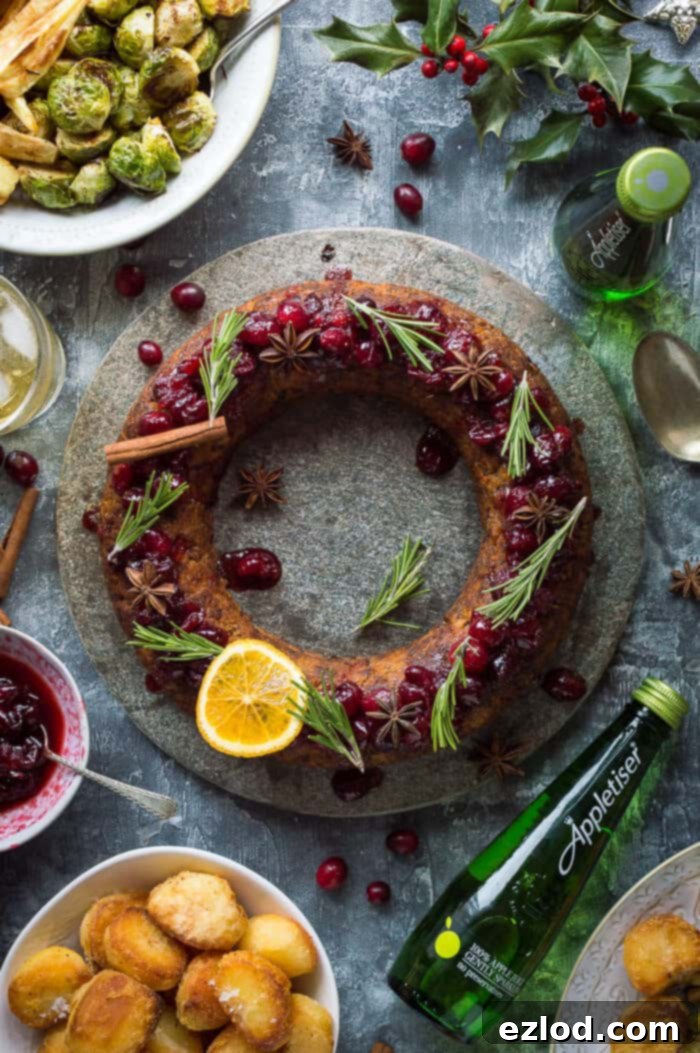 A complete festive vegan nut roast dinner plate featuring the nut roast wreath, golden roast potatoes, vibrant Brussels sprouts, and a dollop of cranberry sauce, ready for serving.
