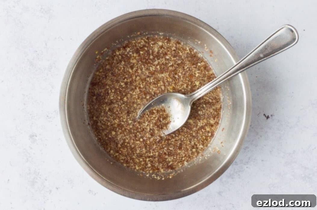 Step-by-step image of preparing a flax egg by mixing ground flaxseed and water in a bowl for the vegan nut roast recipe.