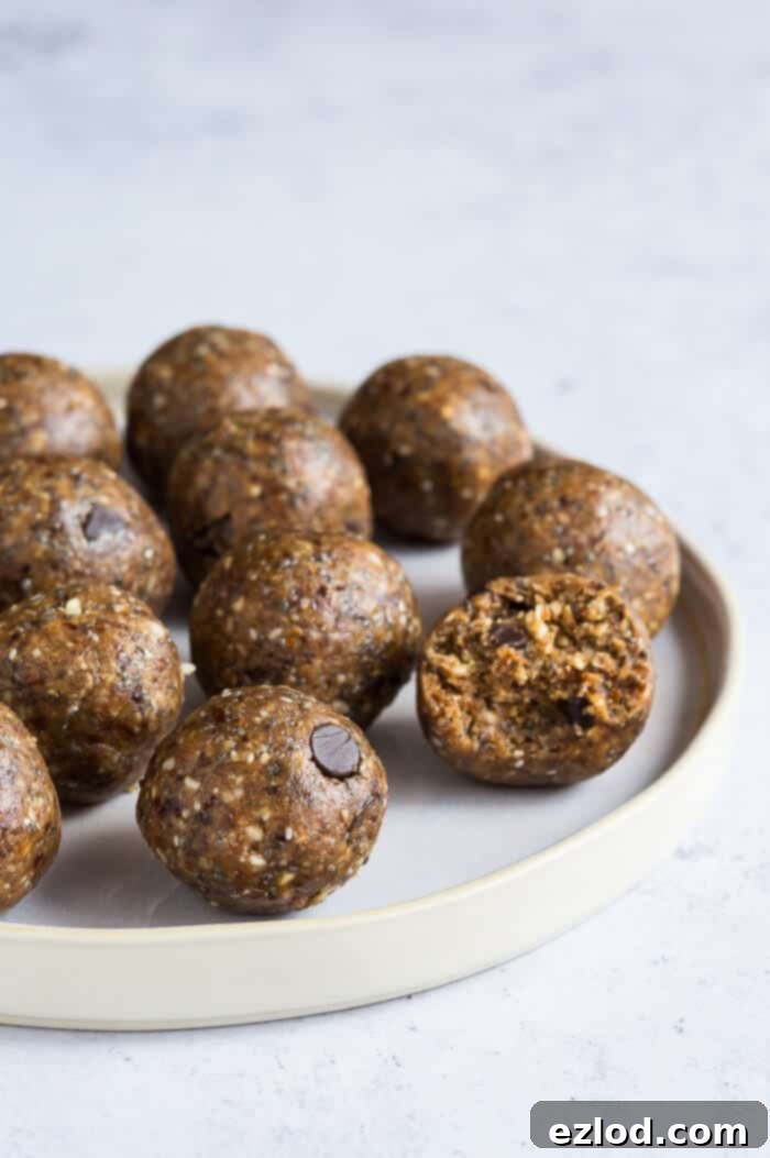 Side angle close-up of several vegan peanut butter chocolate chip cookie dough energy balls, perfectly round and rich in color. The image highlights their appealing texture and snack-ready appearance.