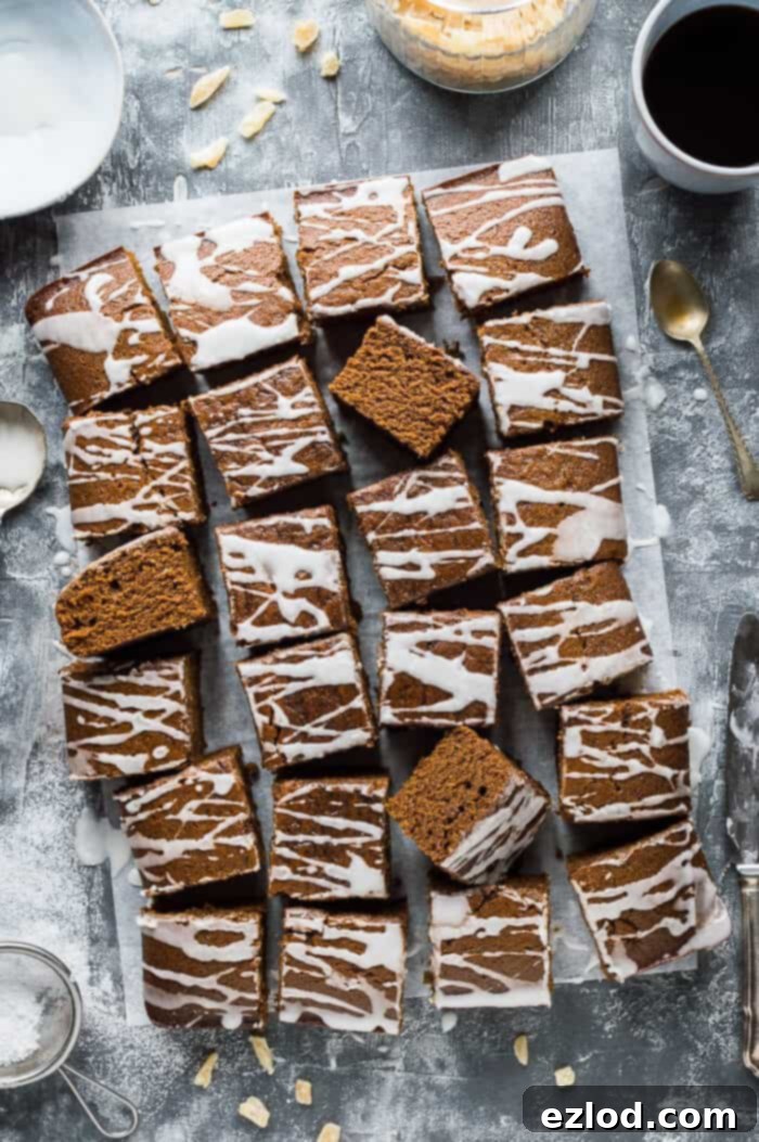 Easy vegan ginger sheet cake with lemon glaze on a grey background with candied ginger and a cup of coffee.