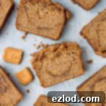 A top-down view of a beautifully baked vegan Biscoff banana bread with a golden-brown streusel topping, ready to be sliced, emphasizing its inviting texture and presentation.