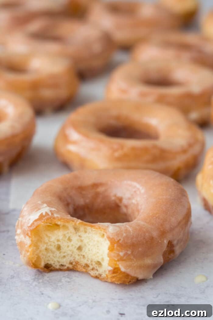 Vegan glazed doughnuts - these egg and dairy free fried ring doughnuts are incredibly light and fluffy. Topped with a vanilla glaze they are so moreish and very similar to a Krispy Kreme. #vegan #donut #doughnut
