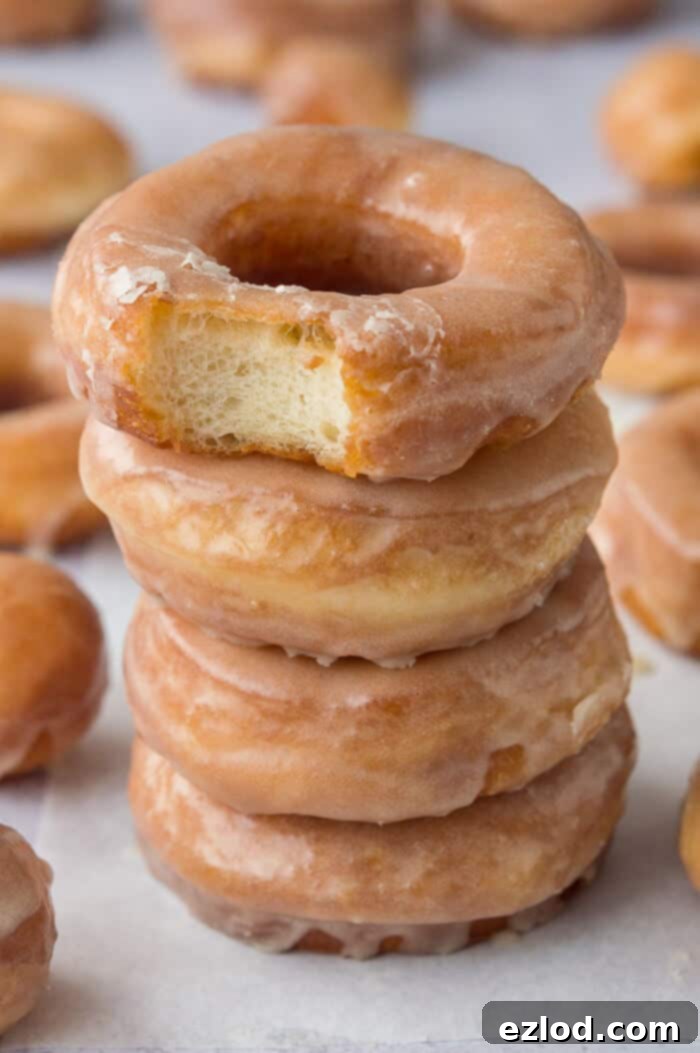 A stack of four vegan fried vanilla glazed doughnuts.