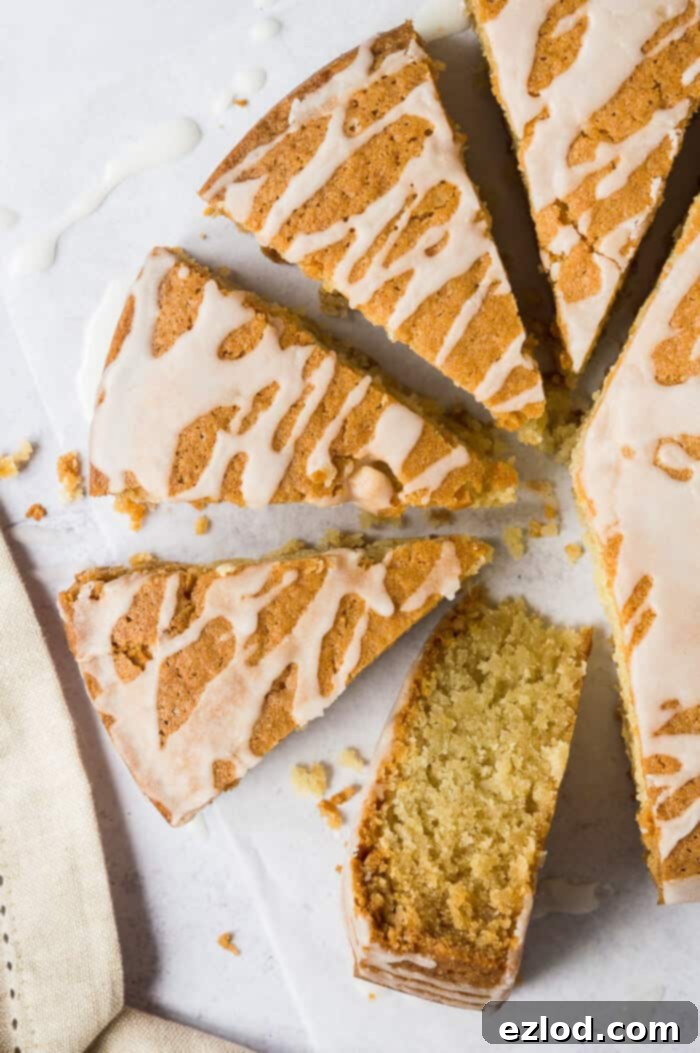 A close-up view of a slice of vegan coconut cake, showcasing its moist crumb and the rich texture, garnished with a light lemon glaze drizzle. This eggless and dairy-free cake is a testament to delicious plant-based baking. #vegancake #coconutcake #egglessbaking #dairyfree