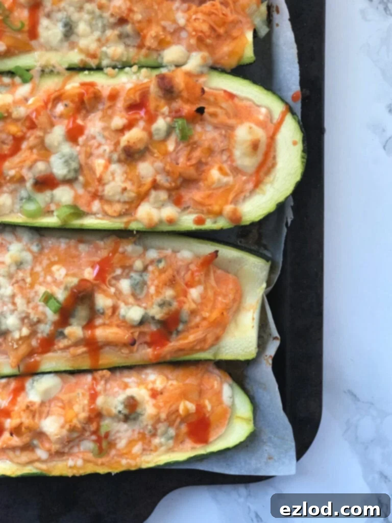 A close up of Buffalo Chicken Stuffed Zucchini Boats on a baking sheet