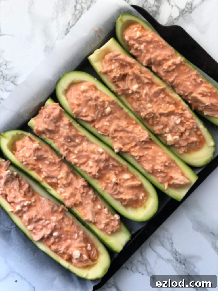 A baking sheet filled with Buffalo Chicken Zucchini Boats ready to go in the oven