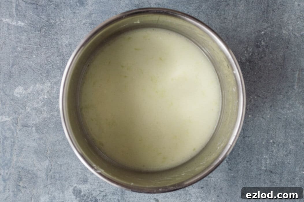Step one of making vegan coconut lime curd: whisking cornflour into fresh lime juice in a stainless steel saucepan.