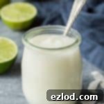 Vegan Coconut Lime Curd 6 A small glass jar of vegan coconut lime curd with a spoon in it.