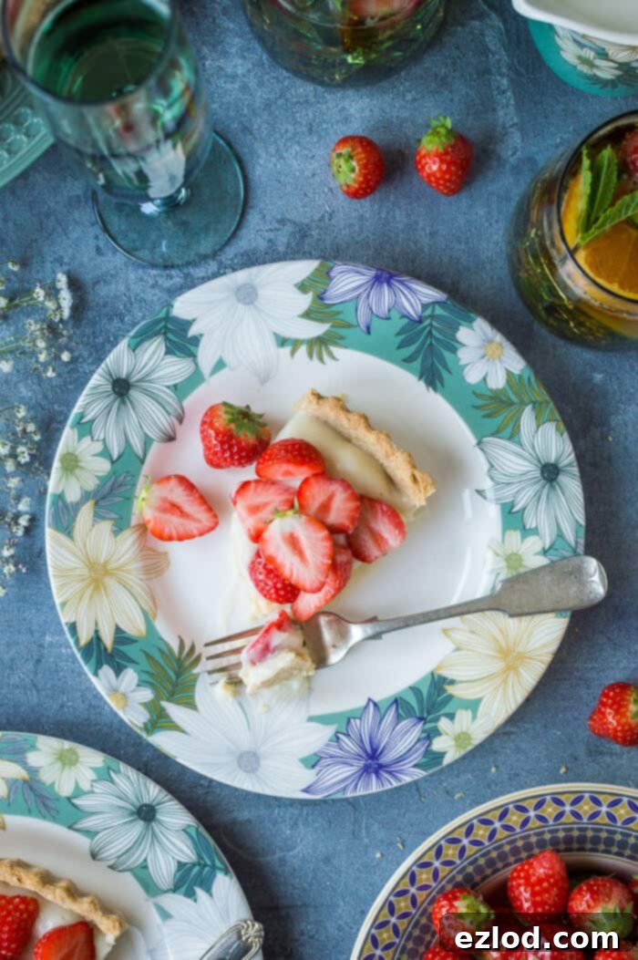A perfectly sliced piece of vegan strawberry tart resting on a charming floral plate, inviting a taste of summer.