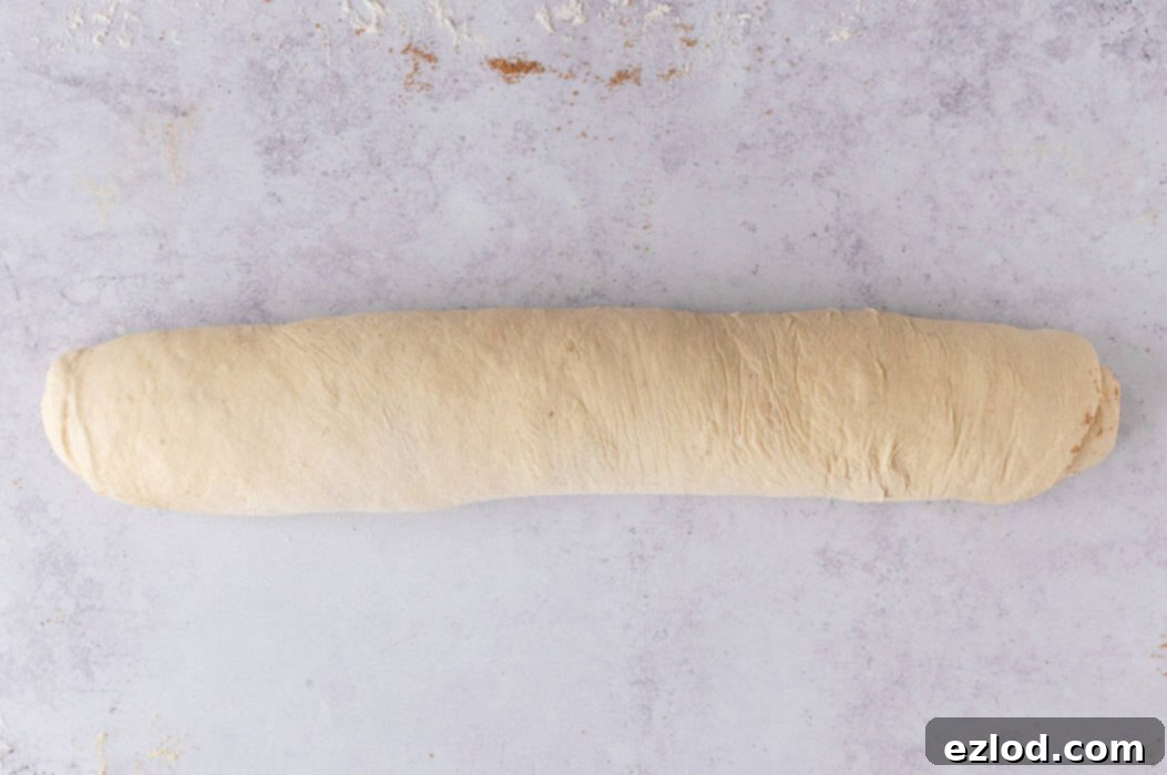 Step 6: Tightly rolling up vegan banana bread dough filled with cinnamon sugar.